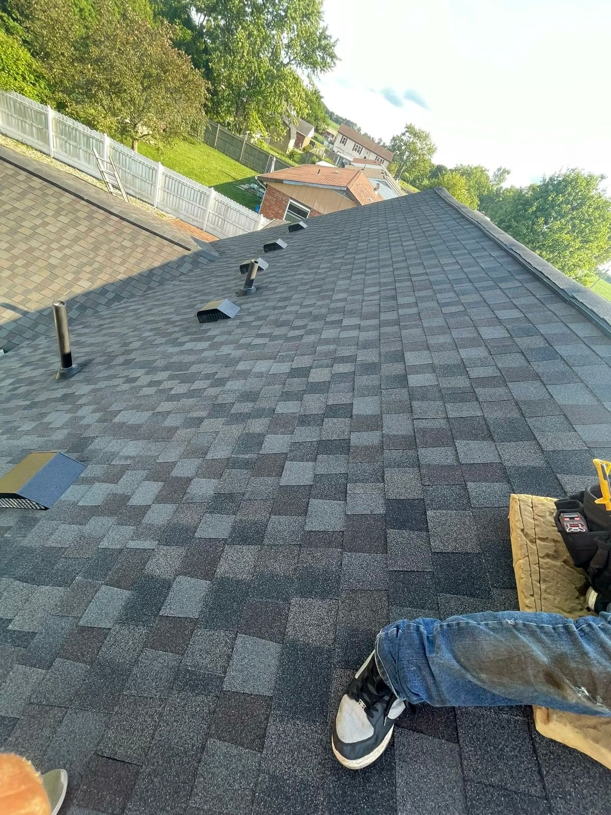 Close-up of a new architectural shingle field with ridge and pipe vents