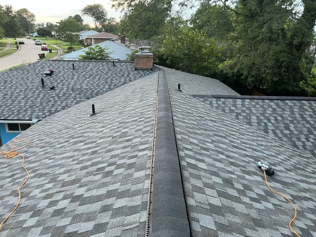 New ridge vent running along the peak of a completed gray shingle roof